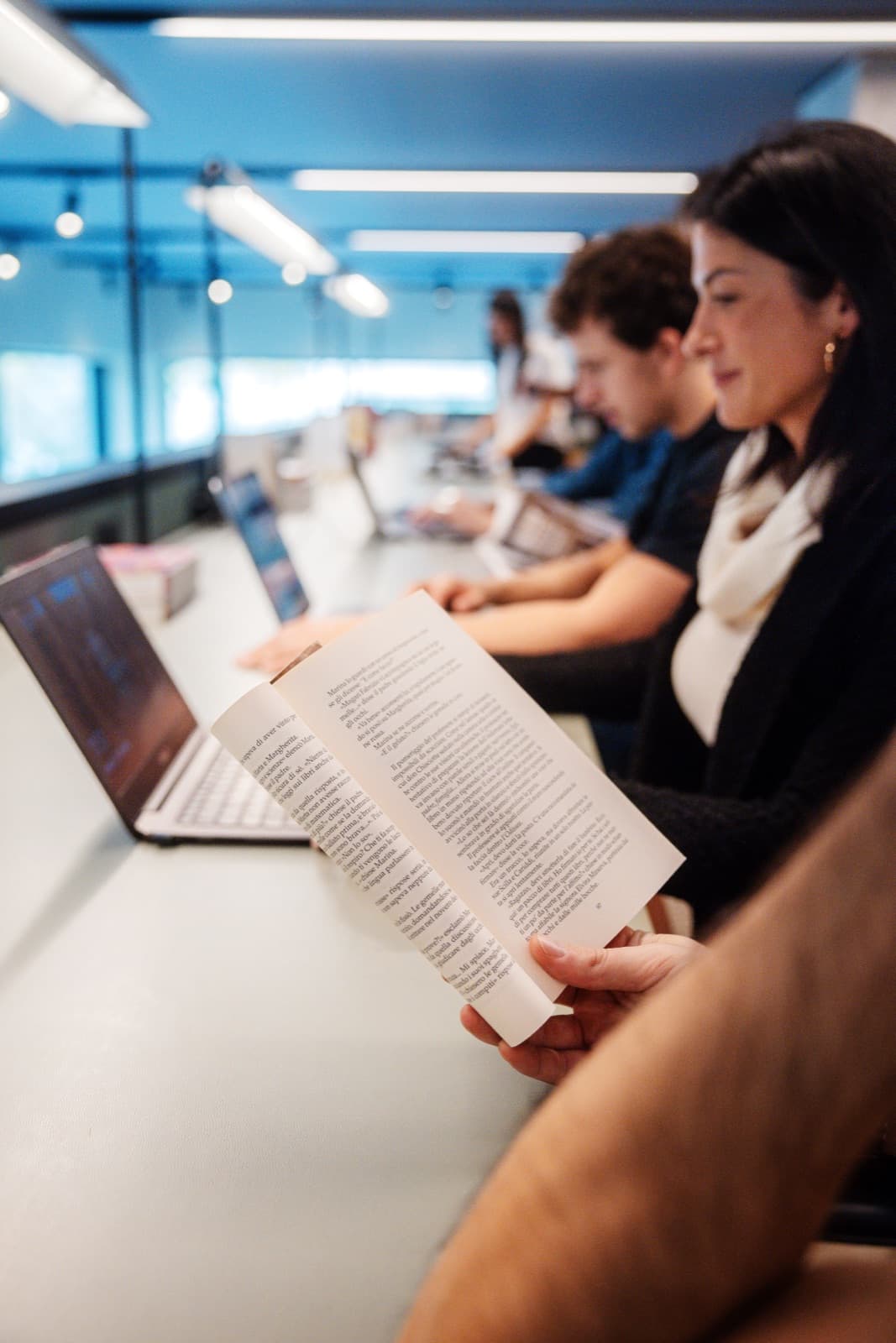 Lettura e laptop al tavolo lungo del coworking