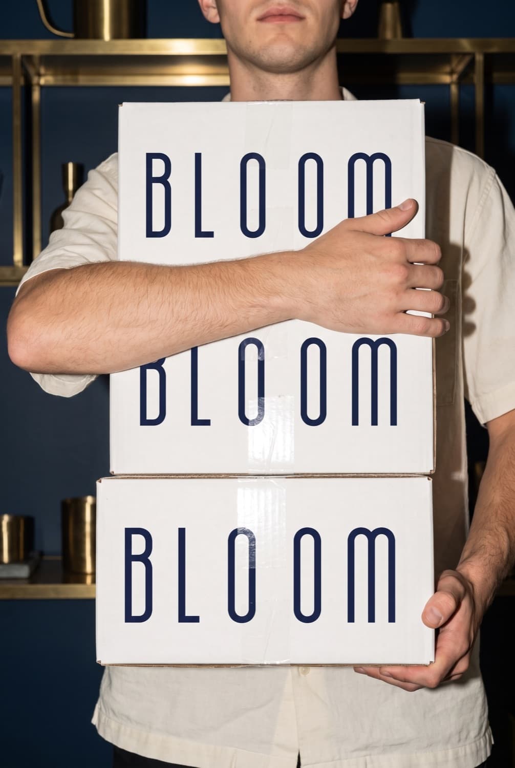 A young man holding three Bloom boxes